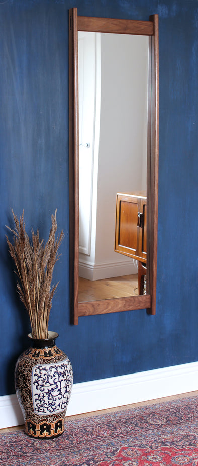 The Currach Mirror is a full-length mirror made from black American walnut with native Irish pear wedges.&nbsp;  The sweeping asymmetrical bow of the sides is reminiscent of the curve of a currach.&nbsp; The rails are joined to the sides with&nbsp; pear wedged-through tenons.  D61 x W425 x H1381mm