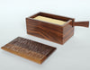 This Japanese-inspired walnut buttter-box / butter dish has been crafted entirely with hand-tools and natural materials, all entirely food-safe.  The delicately bevelled edges and carved top are a pleasure&nbsp;to handle. &nbsp;A butter knife, carved from the same piece of wood sits neatly inside ready for use.  H84 x D98 x W170mm  Irish craft handmade in Dublin, Ireland for Gallery33